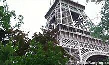 Dua lelaki yang berbakat memuaskan seorang gadis yang cantik di tempat awam berhampiran Menara Eiffel