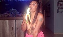 デシガールがバナナで口技を練習しながら小さな胸を見せつける