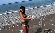 Geile tiener brunette met enorme neptieten poseert recht op het strand