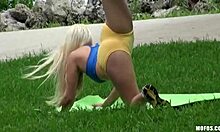 Blonde yogaster traint in een openbaar park