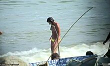 Bomba sin camisa mostrando sus tetas firmes en una playa nudista