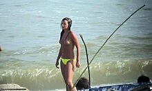 Bomba sin camisa mostrando sus tetas firmes en una playa nudista