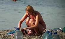 胸部丰满的金发女郎在裸体海滩上做事,看起来很性感