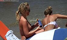 Szőke barátnők mutogatják a melleiket és forró testüket a tengerparton