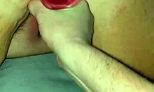 Lähikuva vaaleanpunaisesta dildosta, joka tunkeutuu pehmeään pilluun