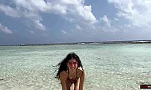 Златен душ на плажа в Малдивите за красива момиче, което пикае