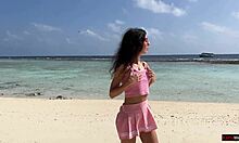 Douche dorée sur une plage des Maldives pour une belle fille qui fait pipi